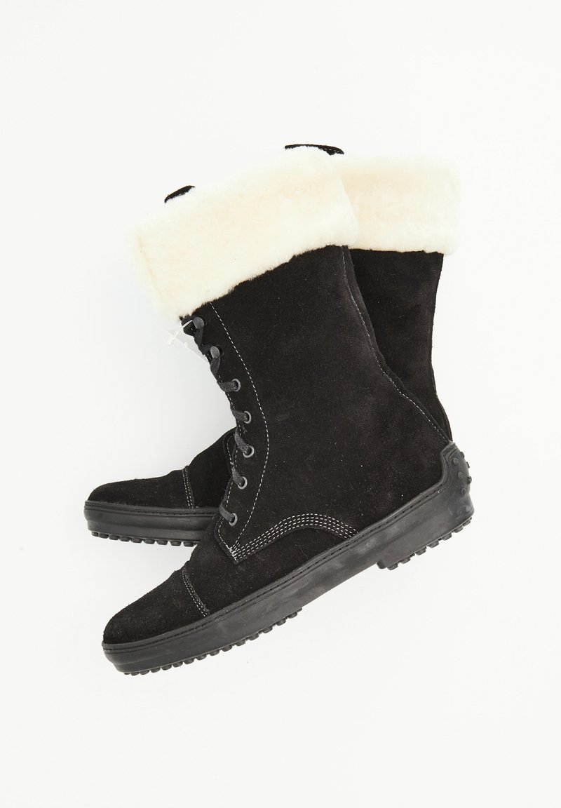 Bottes en daim noir avec un manchon en fourrure blanche, bout rond et design à lacets. Semelle en caoutchouc avec motif texturé pour une meilleure adhérence.