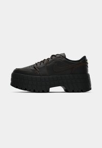 Czarne skórzane sneakersy Nike z grubą, teksturowaną podeszwą oraz brązowym szwem na jednolitym białym tle.