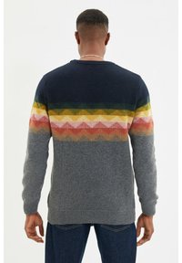 Strickpullover mit einem Farbverlauf aus bunten Zickzackstreifen im oberen Teil, einer grauen unteren Sektion und einem gerippten Saum.