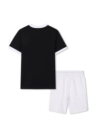 Zwarte T-shirt met korte mouwen en witte afwerking, gecombineerd met witte shorts met een subtiele, herhalende logopatroon. Zachte stof, casual ontwerp.