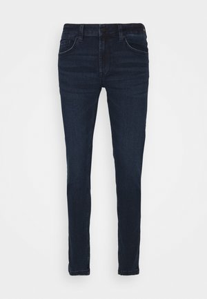 Jeans de denim oscuro ajustados con un lavado medio, que cuentan con bolsillos tradicionales y costuras en contraste, textura suave y una cintura estándar.