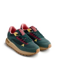 Un par de zapatillas verdes y rosas con malla negra, acentos amarillos, suelas gruesas de color beige y diseño de cordones, en un ángulo que muestra la parte delantera y lateral.