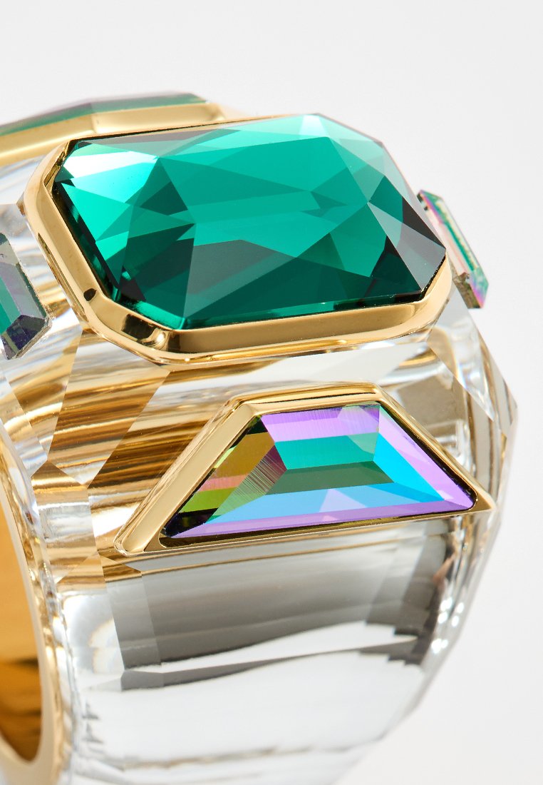 Klarer Armreif mit goldenen Akzenten, der große grüne und lila geometrische Kristalle enthält. Glatte Textur mit eckigen Facetten und glänzender Oberfläche.