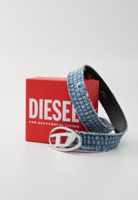 Denimbelte med flossete kanter, med en sølvfarget logo-spenne. Kommer med en rød boks merket "DIESEL FOR SUCCESSFUL LIVING."