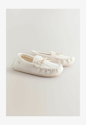 Hvide, blødt teksturerede tøfler med moccasin-design, der har en syet kant og en dekorativ sløjfe. Foret indvendigt for komfort.