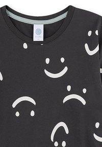 Schwarzes Crewneck-Shirt mit verstreuten weißen Smiley- und traurigen Gesichtern in verschiedenen Ausrichtungen.