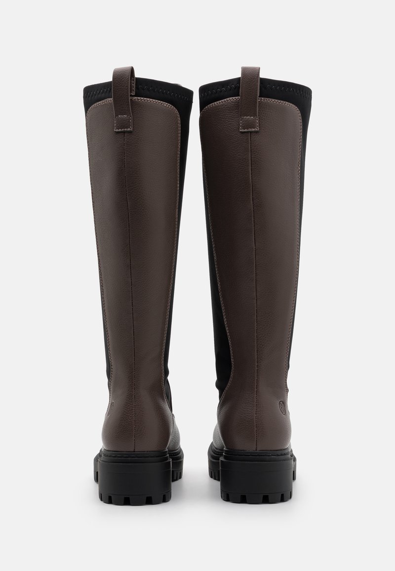 Bottes en cuir marron montantes avec une tige noire texturée. Elles possèdent une semelle en caoutchouc durable et des détails cousus le long des coutures.