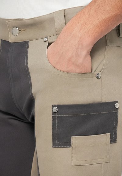 Beige en donkergrijze werkbroek met een knoopsluiting, zijzak en één lagere patch zak; gemaakt van duurzame stof.
