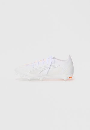 White soccer cleat featuring a textured upper, lightweight design, orange accents on the laces, and clear studs for traction.
