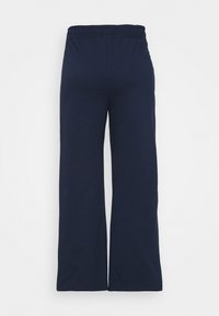Pantaloni a gamba larga color navy con elastico in vita, realizzati in un tessuto morbido. Il design presenta una texture liscia e senza motivi o accenti visibili.