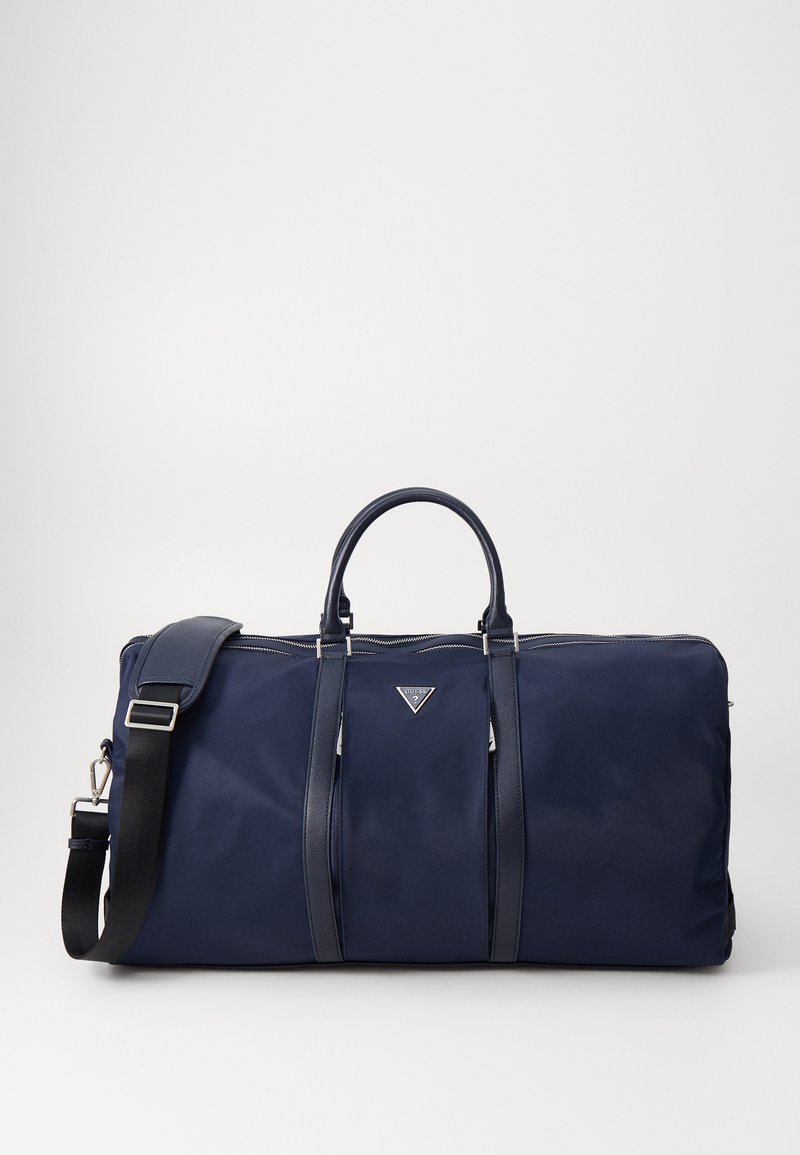 Marine duffelbag laget av slitesterkt stoff, med doble håndtak, en avtagbar skulderreim og et sølvfarget logoakcent på forsiden.