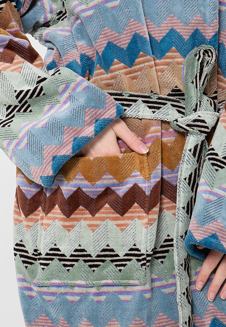 Accappatoio testurizzato con motivi a zigzag in blu, rosa, marrone e crema. Dotato di cintura e tasche frontali. Tessuto morbido.