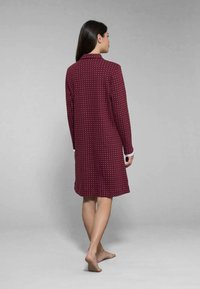 Nuisette bordeaux con una texture a fantasia, maniche lunghe, colletto e dettagli bianchi ai polsini, design fino al ginocchio.