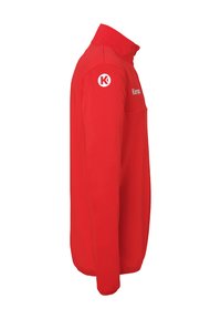 Rode fleecejas met een hoge kraag, lange mouwen en een ritszak. Heeft een logo op de linkerschouder en een zachte textuur.