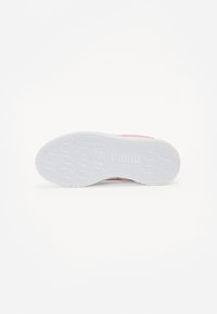Chaussure de sport avec une tige rose et une semelle en caoutchouc blanc. La semelle présente une texture à motifs et un détail de logo. Texture lisse avec une forme arrondie.