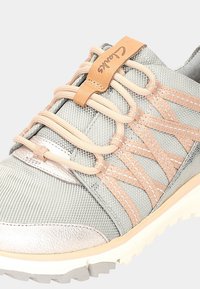 Szare buty z materiału z metalicznymi srebrnymi akcentami. Posiadają elastyczne sznurówki i beżową skórzaną metkę. Teksturowana powierzchnia i wytrzymała biała podeszwa.