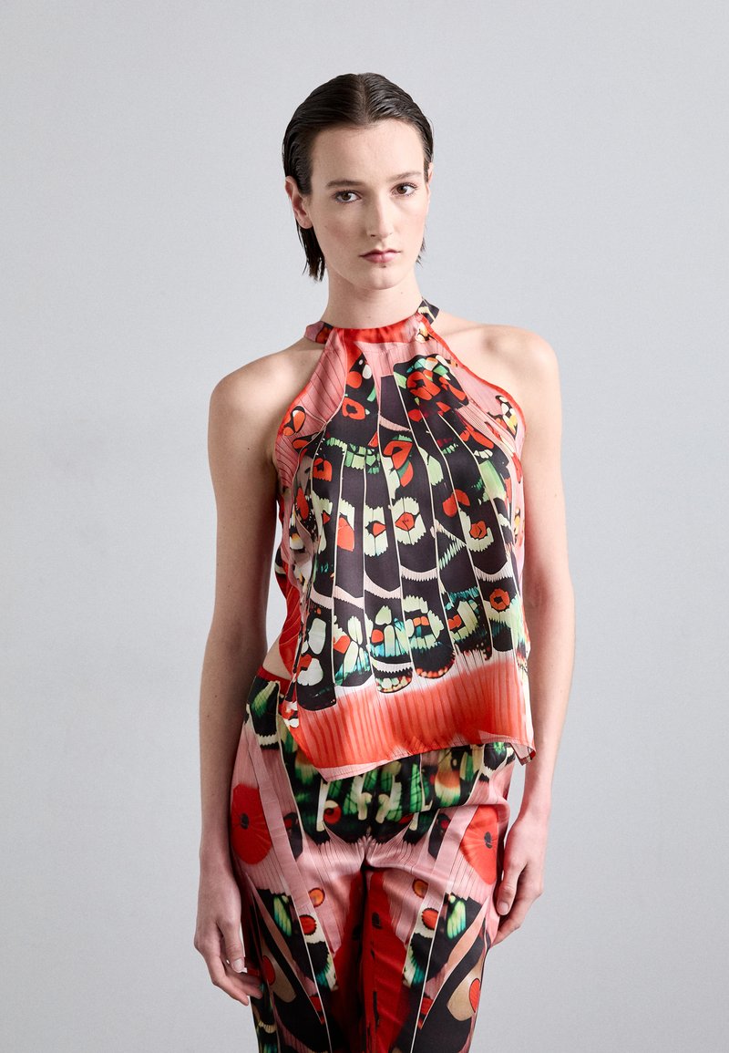Seiden-Haltertop mit auffälligen floralen und federartigen Mustern in Rot, Grün und Schwarz, fließender Silhouette und gepunkteter Textur.
