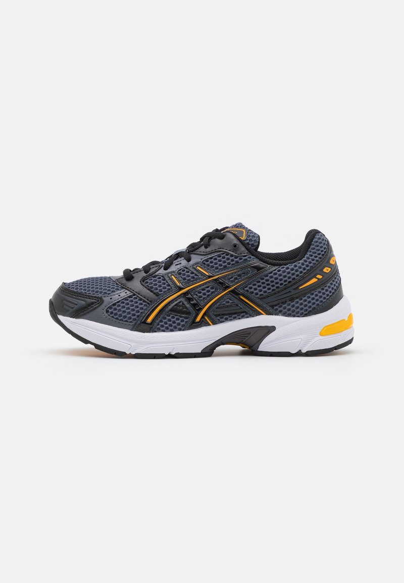 Chaussure de course en mesh gris foncé et noir avec des touches jaunes et une semelle blanche, vue de côté extérieur sur fond blanc.