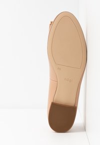Semelle de chaussure femme beige avec talon bloc, taille 4 1/2, affichant le nom de la marque « högI » sur une surface lisse.