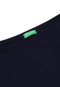 Marineblaue T-Shirt mit rundem Ausschnitt. Verfügt über einen gestickten Saum und ein grünes Etikett mit der Aufschrift "UNITED COLORS OF BENETTON". Glatte Textur.