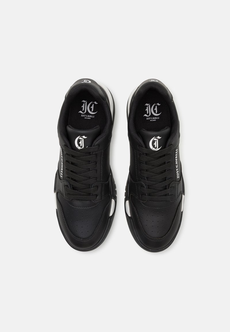Czarne sportowe sneakersy ze skórzaną cholewką, białymi akcentami, teksturowanym noskiem i wyraźnym logo na języku oraz boku. Klasyczny design sznurowany.