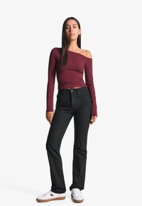 Maroon off-the-shoulder long-sleeve top, black straight-leg jeans, white sneakers with gum soles, minimalistic design, smooth texture.