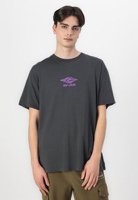 Gray cotton t-shirt with short sleeves, featuring a purple logo at the center. Simple design with a relaxed fit and smooth texture.