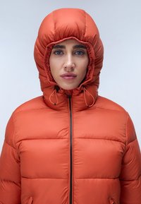Felle oranje donsjas met een strakke capuchon, een rits aan de voorkant en een contrasterende zwarte rits. Heeft een geblokt ontwerp voor isolatie.