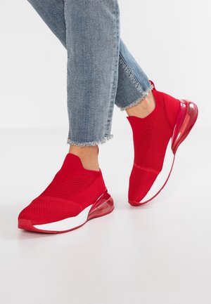 Röda stickade sneakers med slip-on design, som har en genomskinlig röd sula och vita accenter. Strukturerad överdel och en slank form.