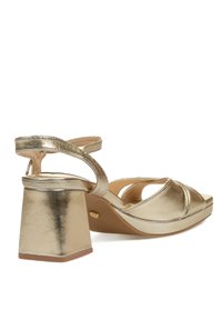 Sandalias de tacón doradas metálicas con un tacón cuadrado grueso, punta abierta y diseño de tiras entrecruzadas para un ajuste seguro. Textura suave.