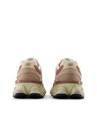 Vista trasera de unas zapatillas New Balance en ante beige y marrón, con una parte superior texturizada, suela acolchada y un acento translúcido en contraste.