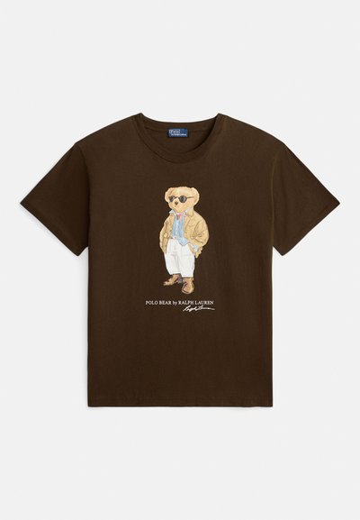 Brązowy bawełniany T-shirt z grafiką niedźwiedzia w okularach przeciwsłonecznych i kurtce, z napisem "POLO BEAR by RALPH LAUREN" nadrukowanym poniżej.