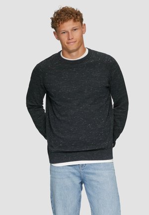 Donkergrijze sweatshirt met een gestructureerde breisel, ronde hals, lange mouwen en een licht ontspannen pasvorm, gedragen over een wit T-shirt en blauwe jeans.