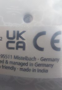 Label features "UKCA," "CE," and text indicating origin and management locations. Background includes a subtle pattern.