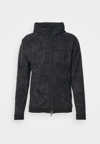 Sweat à capuche zippé noir avec un motif moucheté subtil, manches longues et poignets ajustés, présenté sur un fond clair uni.