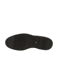 Semelle de chaussure noire en caoutchouc avec des rainures et des crêtes texturées, présentant un logo et un petit emblème coloré. Design principalement plat.