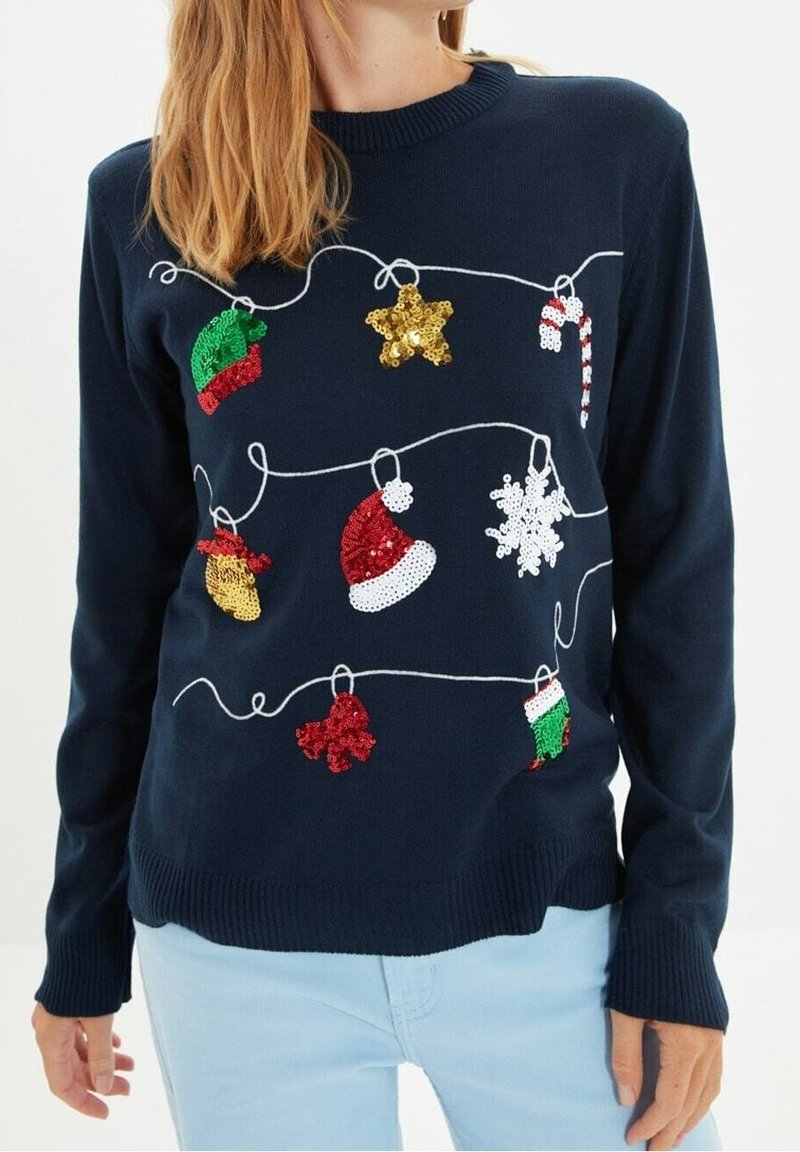 Dunkelblauer Pullover mit bunten, glitzernden Weihnachtsornamenten, darunter Hüte, Sterne und Schneeflocken, umrandet von weißem Stickerei.