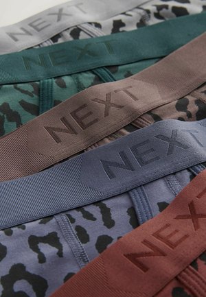 Fire par shorts med elastiske bånd i nuancer af grå, grøn, brun og blå, hver med mærkenavnet "NEXT" tydeligt fremhævet.