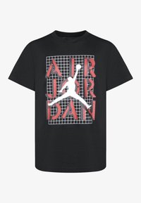 Camiseta negra de manga corta con un gráfico estampado en serigrafía de una silueta saltando y "AIR JORDAN" en letras rojas sobre un fondo de cuadrícula.