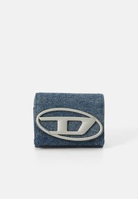 Džínová peňaženka s obdĺžnikovým tvarom; má veľký strieborný logo akcent na prednej strane. Textúrovaná tkanina; modrá farba.