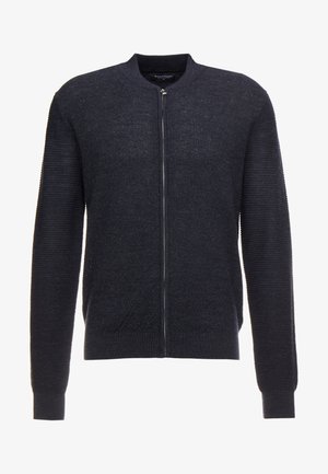 Gilet en tricot bleu marine avec un col rond et des manches longues, doté d'une fermeture éclair à l'avant et d'un ourlet et de poignets côtelés. Finition en tissu texturé.