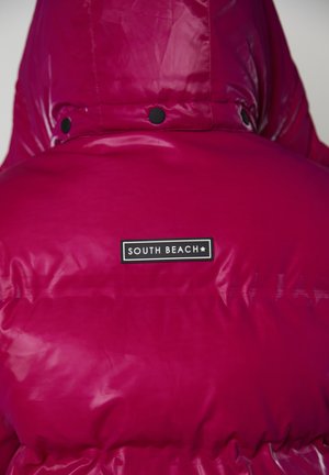 Fuchsia puffer jacket with a shiny, puffy texture and a hood. Features a black label with the text "SOUTH BEACH." Snaps near the neck.