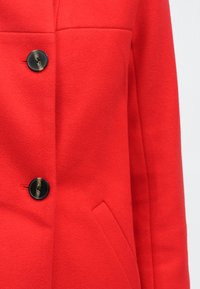 Red wool blend coat with a structured design, featuring a single black button and a side pocket. Smooth texture, tailored fit.