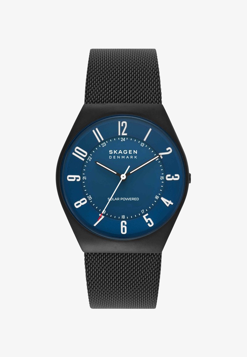 Montre à bracelet en maille noire avec cadran bleu, index blancs, trois aiguilles et le texte "Skagen Denmark Solar Powered" sur le cadran.