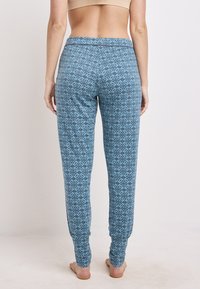 Blauwe legging met een patroon en een aansluitend ontwerp, gemaakt van zachte stof, met een geometrisch print en taps toelopende broekspijpen.