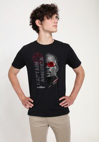 Sort bomulds T-shirt med et grafik af et karakters ansigt med rødtonede goggles, ledsaget af teksten "Captain America" i grå.