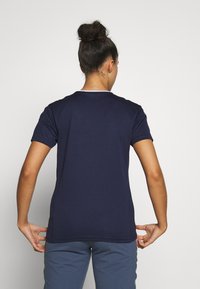 Mørkeblå kortærmet T-shirt med rund hals, der har et enkelt design og en diskret hvid kant rundt om halsudskæringen.