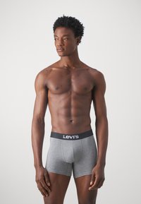 Graue Boxershorts mit einem schwarzen elastischen Bund, der ein weißes "Levi's"-Logo zeigt, eng anliegendes Design, aus weichem Baumwollmischmaterial.
