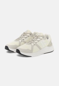 Sneakers leggeri in mesh beige e bianco con dettagli texturizzati. Presentano un collo imbottito e un design con lacci. Suola in gomma nera.