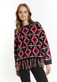 Gebreide trui in zwart, rood en wit met geometrische patronen. Heeft een franjerand en lange mouwen. Gelaagd stof en losse pasvorm.